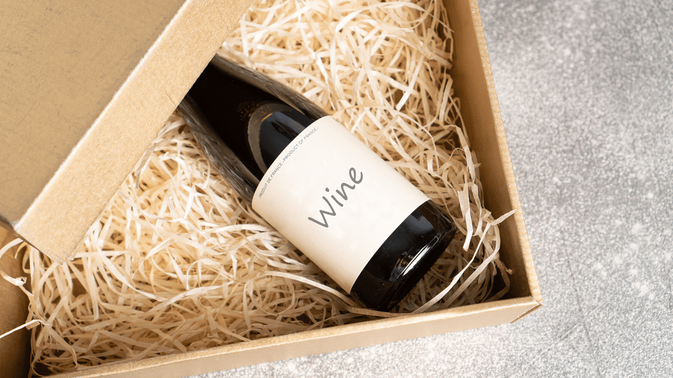 Wine subscription gift box with red and white wine bottles on table